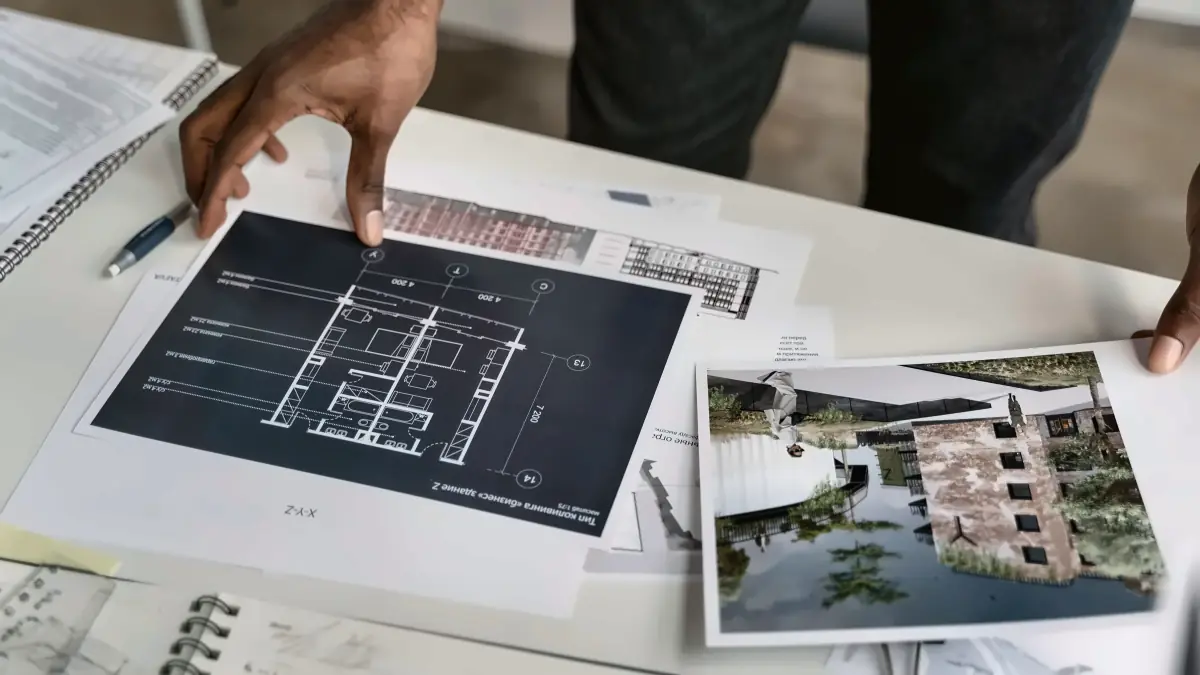 Manos sobre el plano de una vivienda, planificando la obra